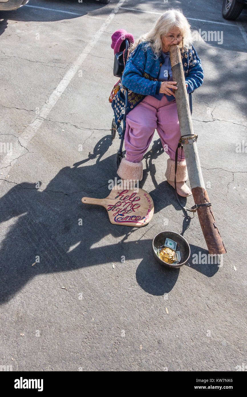 Woman playing didgeridoo at the Santa Barbara, California farmer's