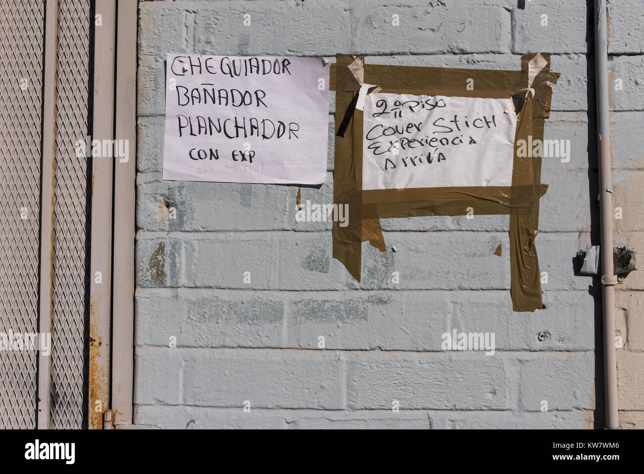 Help wanted signs in Spanish and English, taped to an exterior wall in the Fashion District of Downtown Los Angeles, California. Stock Photo