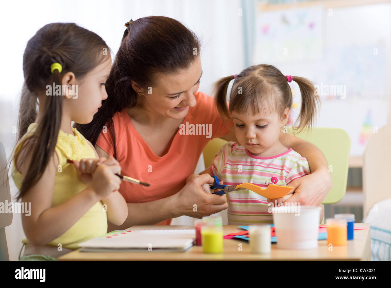 children girls and mother hands making at nursery at home Stock Photo
