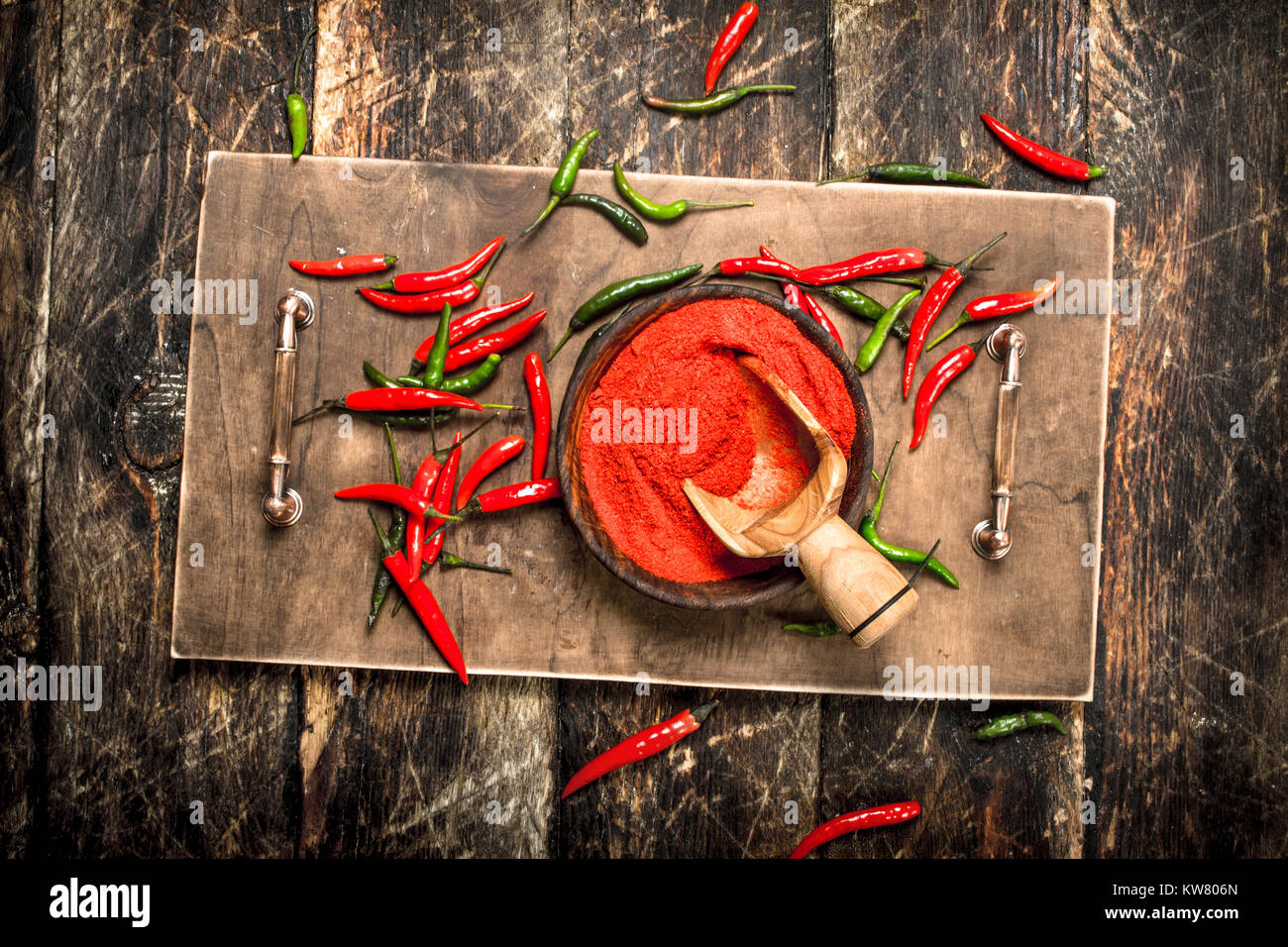 Ground hot chili pepper in a bowl. On a wooden background Stock Photo