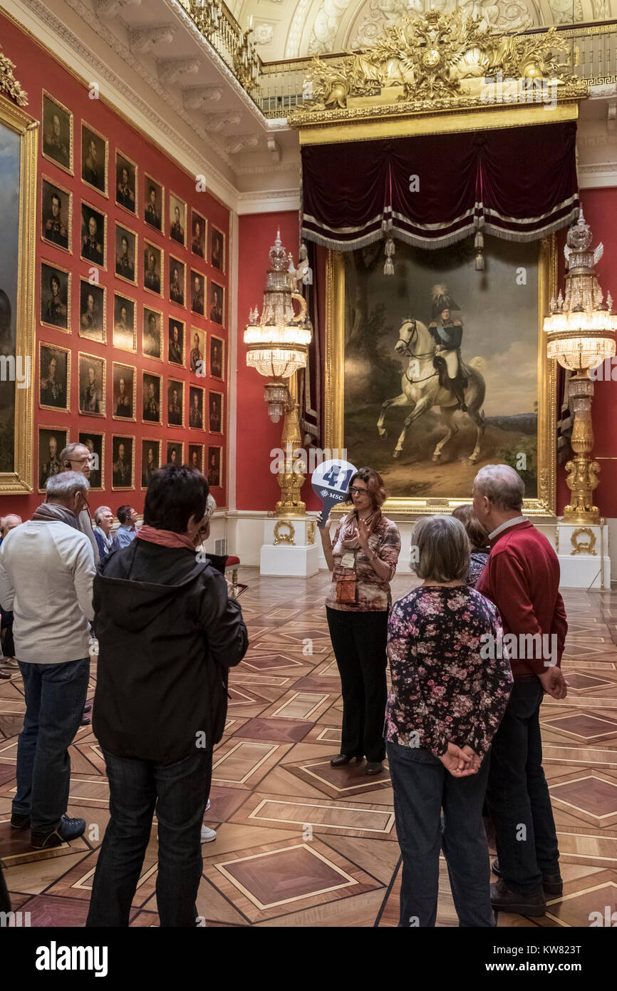 Visitors with tour guide viewing paintings in the 1812 War Gallery at The State Hermitage Museum, Saint Petersburg, Russia Stock Photo