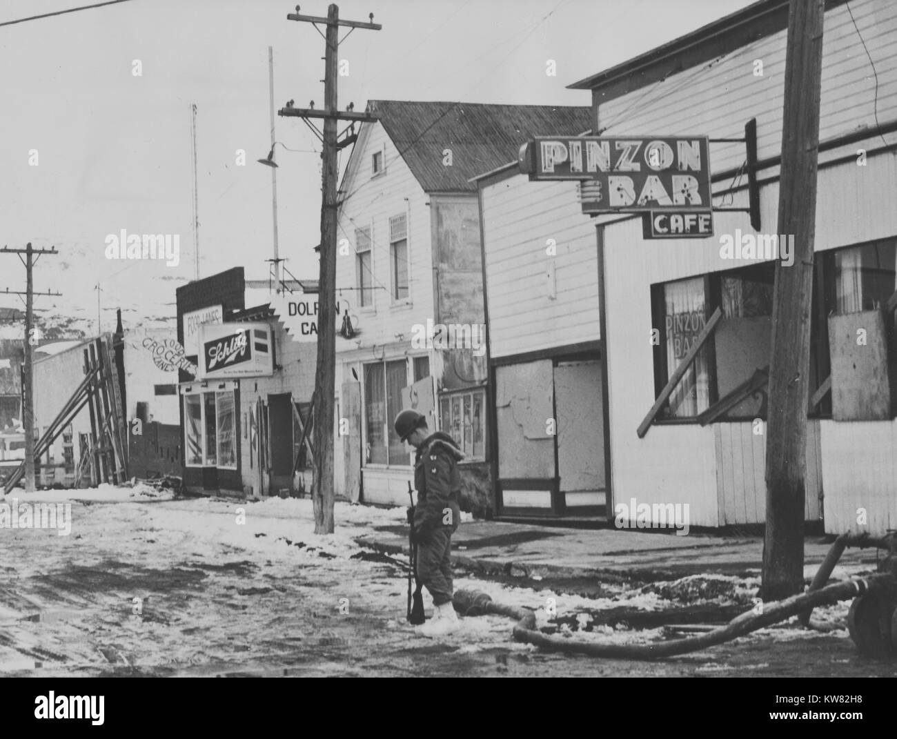 Army guards stationed on a main street in Valdez, Alaska after it was shaken by a tidal wave and earthquake, March 27, 1964. Stock Photo