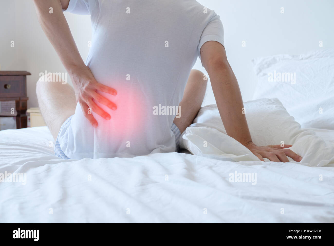 Man feeling back ache in the bed after sleeping Stock Photo
