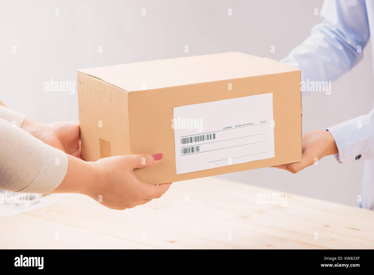 Woman receiving package from a delivery man Stock Photo