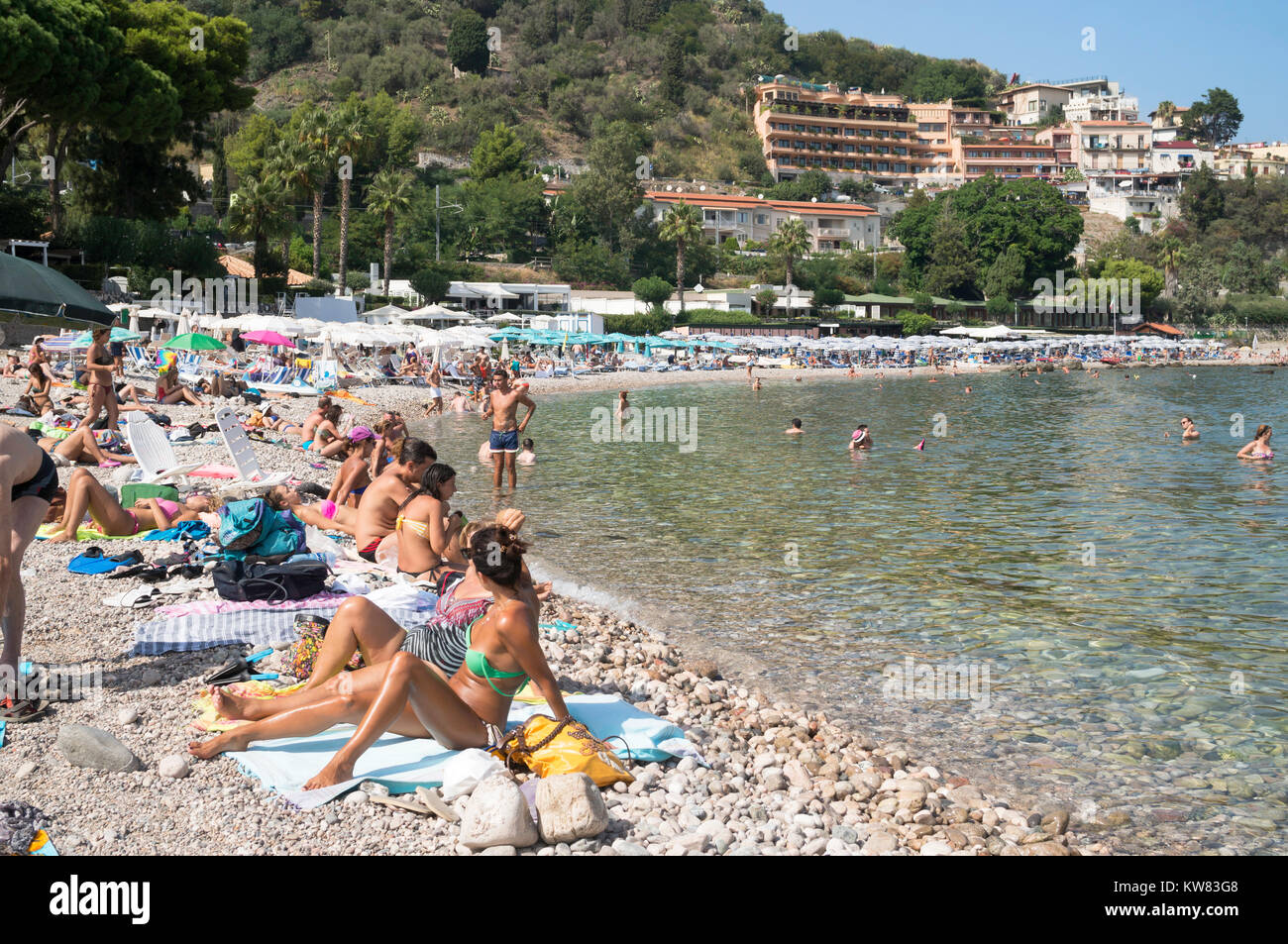 People sunbathing on the beach at Mazzarò, Taormina, Sicily Stock Photo