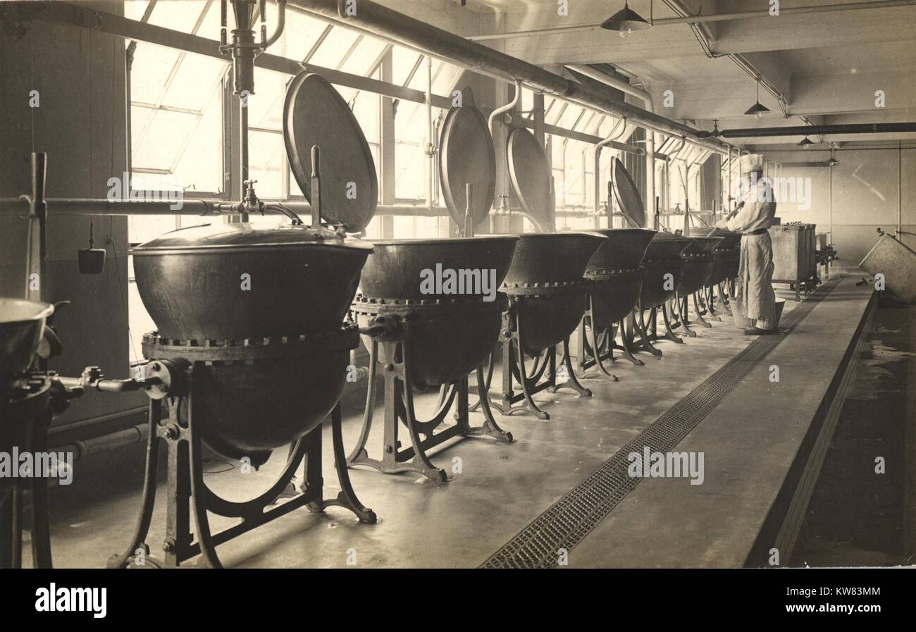 A chef in the kitchen with many copper cooking equipment in a line at King George Military Hospital, London, England, 1915. Stock Photo