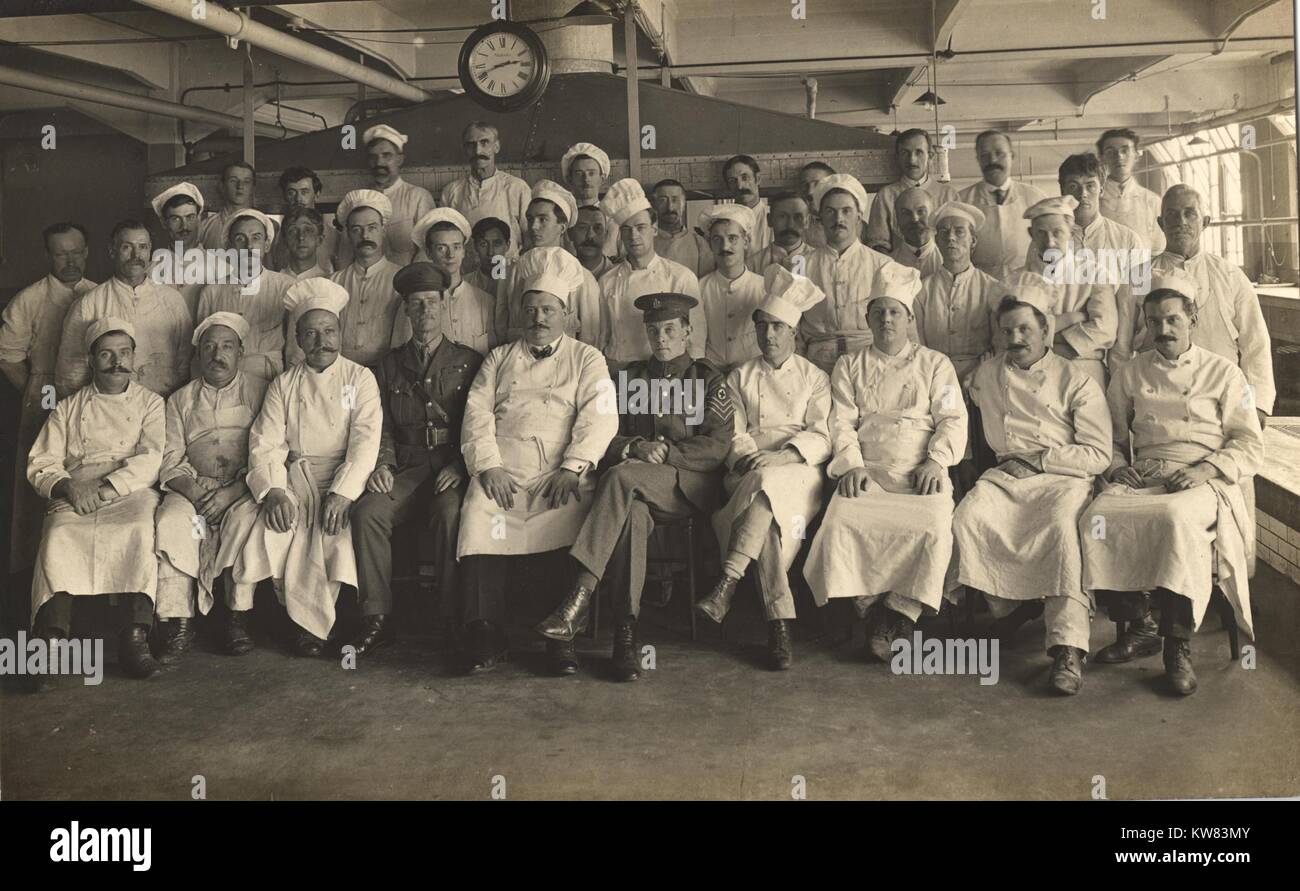 Full staff of cooks in sitting and standing in rows for a group picture at the King George Military Hospital, London, England, 1915. Stock Photo