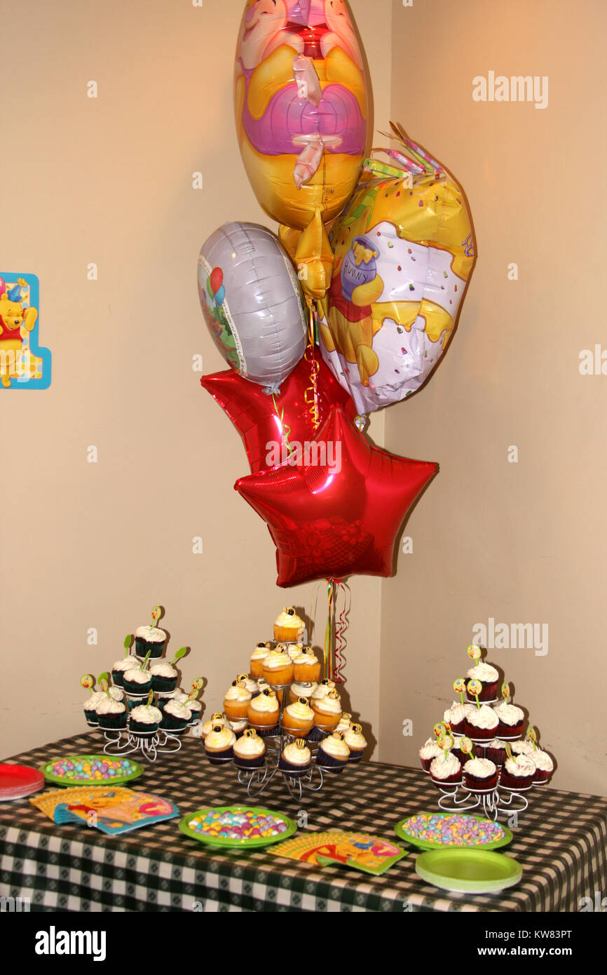 Table, cupcakes and balloons set for birthday party Stock Photo