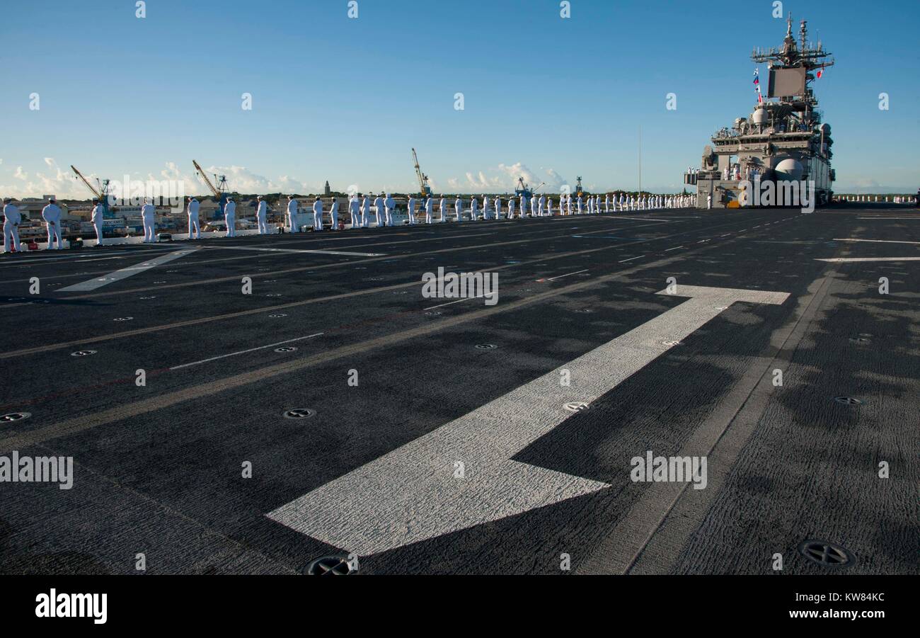 Sailors man the rails on the flight deck of the amphibious assault ship USS Wasp (LHD 1). Wasp is tr Stock Photo