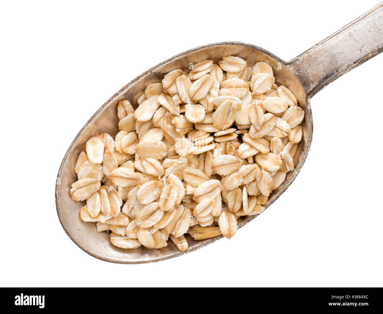 Spoon of organic whole grain oats, coarsely ground. Isolated on white. Stock Photo