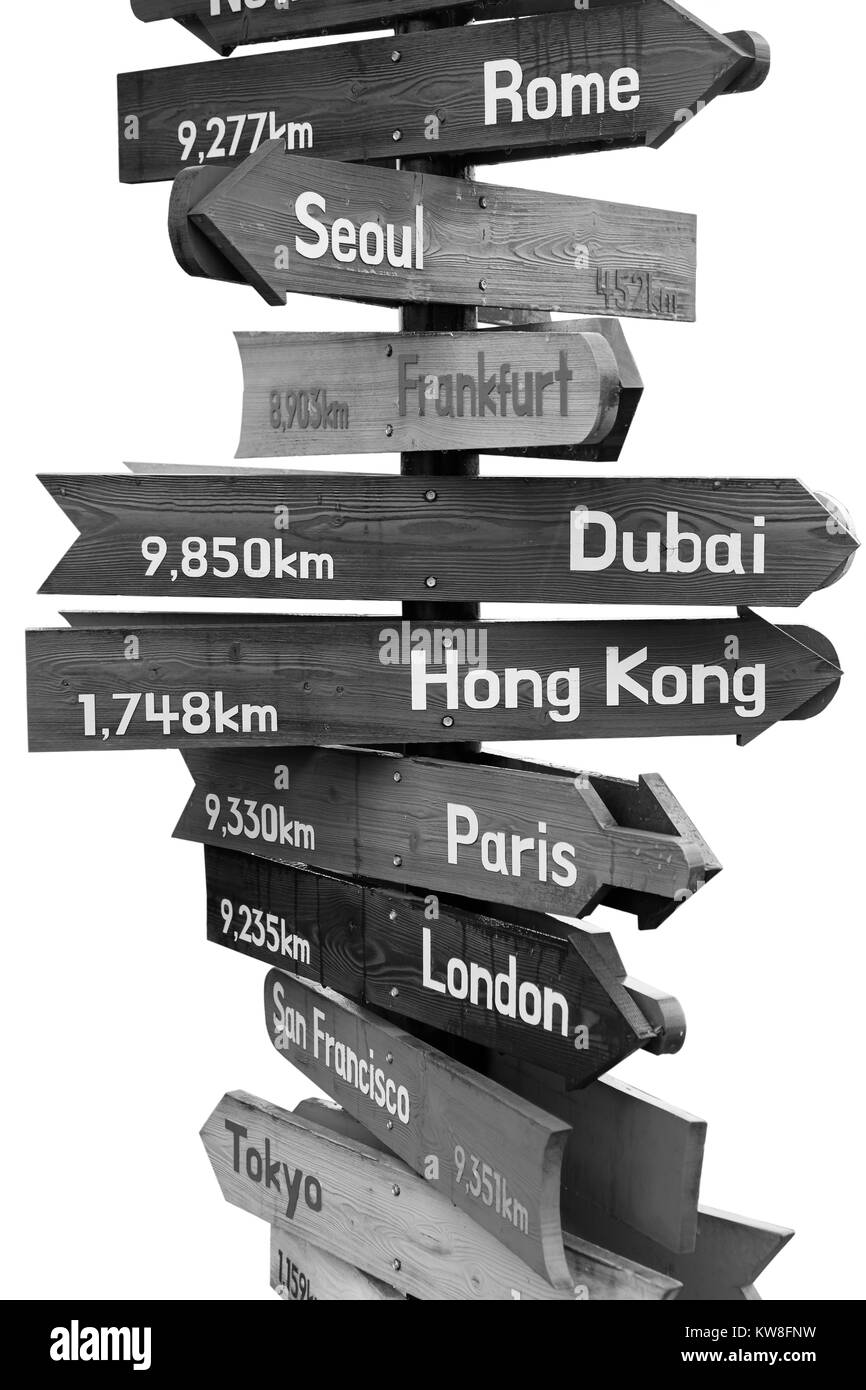 Wooden signpost indicating directions of nine world continents over white background (Black and white) Stock Photo