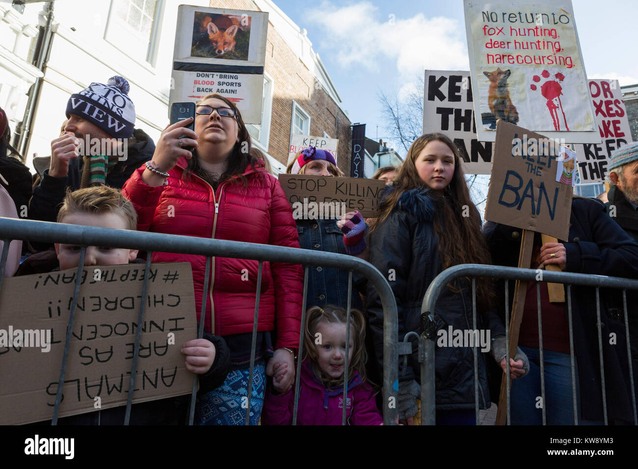 Protesters holding placards demonstrate against fox hunting as the Carmarthenshire Hunt parade through Carmarthen on New Year's Day 2018 Stock Photo