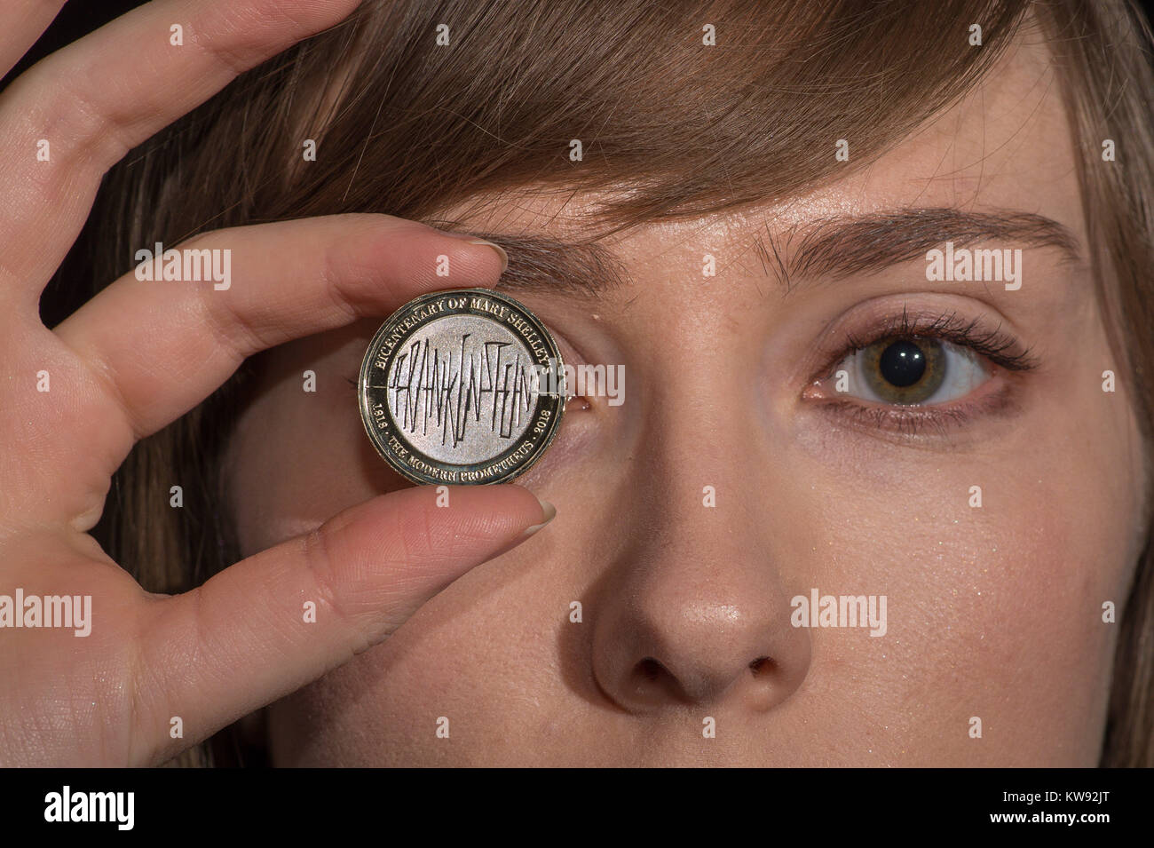 EMBARGOED TO 0001 MONDAY JANUARY 1 Alex Powell from the Royal Mint, Llantrisant, Wales, holds a &pound;2 coin from the Royal Mint featuring a Frankenstein design commemorating 200 years after the publication of Mary Shelley's classic science fiction novel. Stock Photo