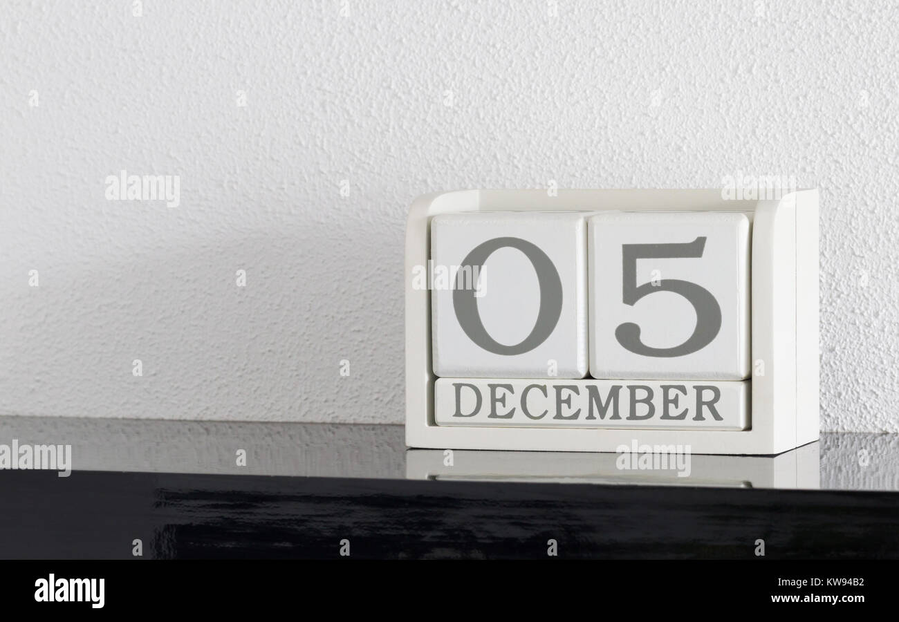White block calendar present date 5 and month December on white wall ...