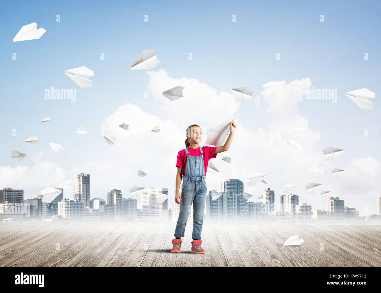 Cute kid girl stand on wooden floor and paper planes flying around ...