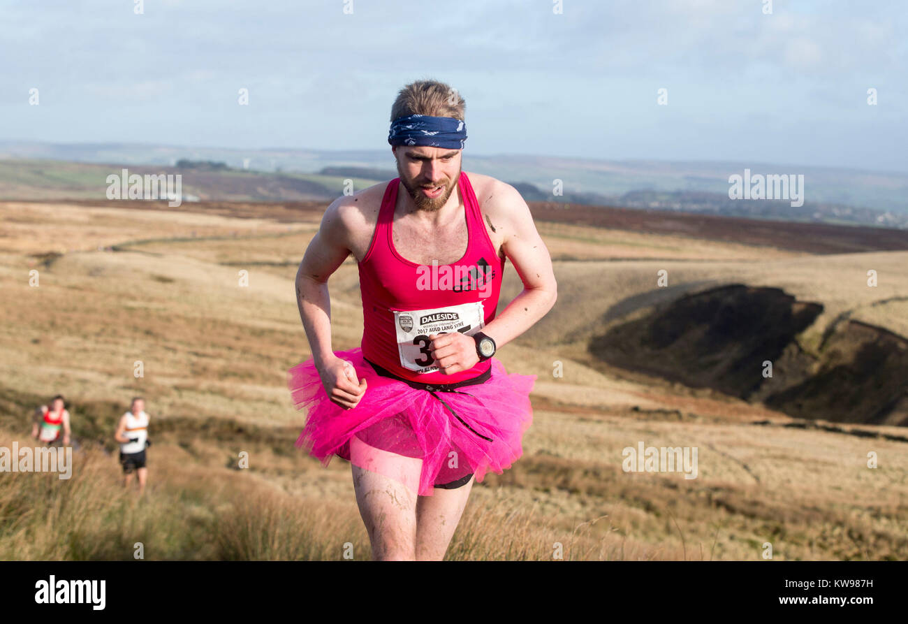A competitor in fancy dress runs across the Pennine tops near Haworth in the traditional Auld Lang Syne Fell race which attracts hundreds of runners, many in costume. Stock Photo