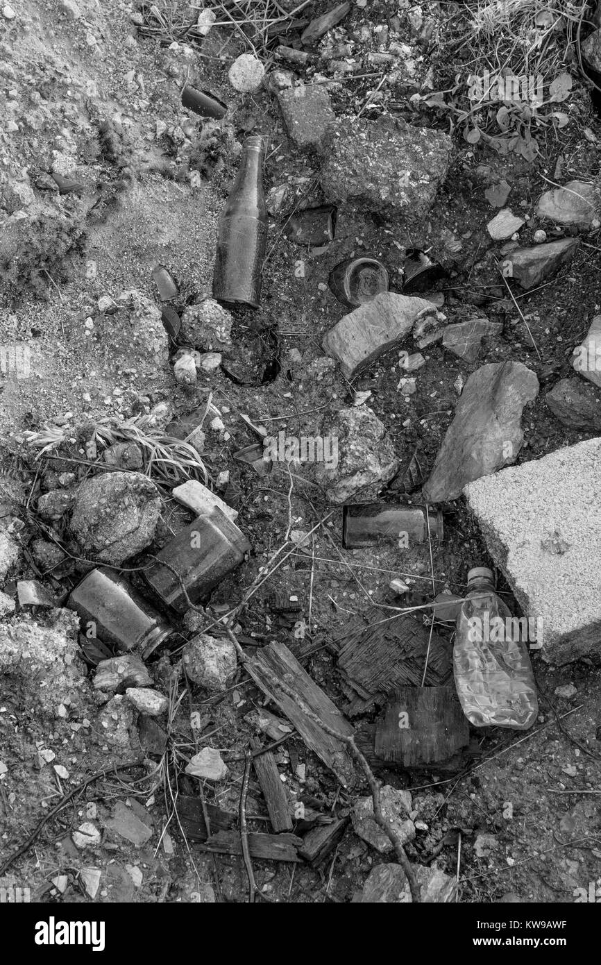 Black and white image (colour conversion) of bottles and other building rubbish tipped. Stock Photo