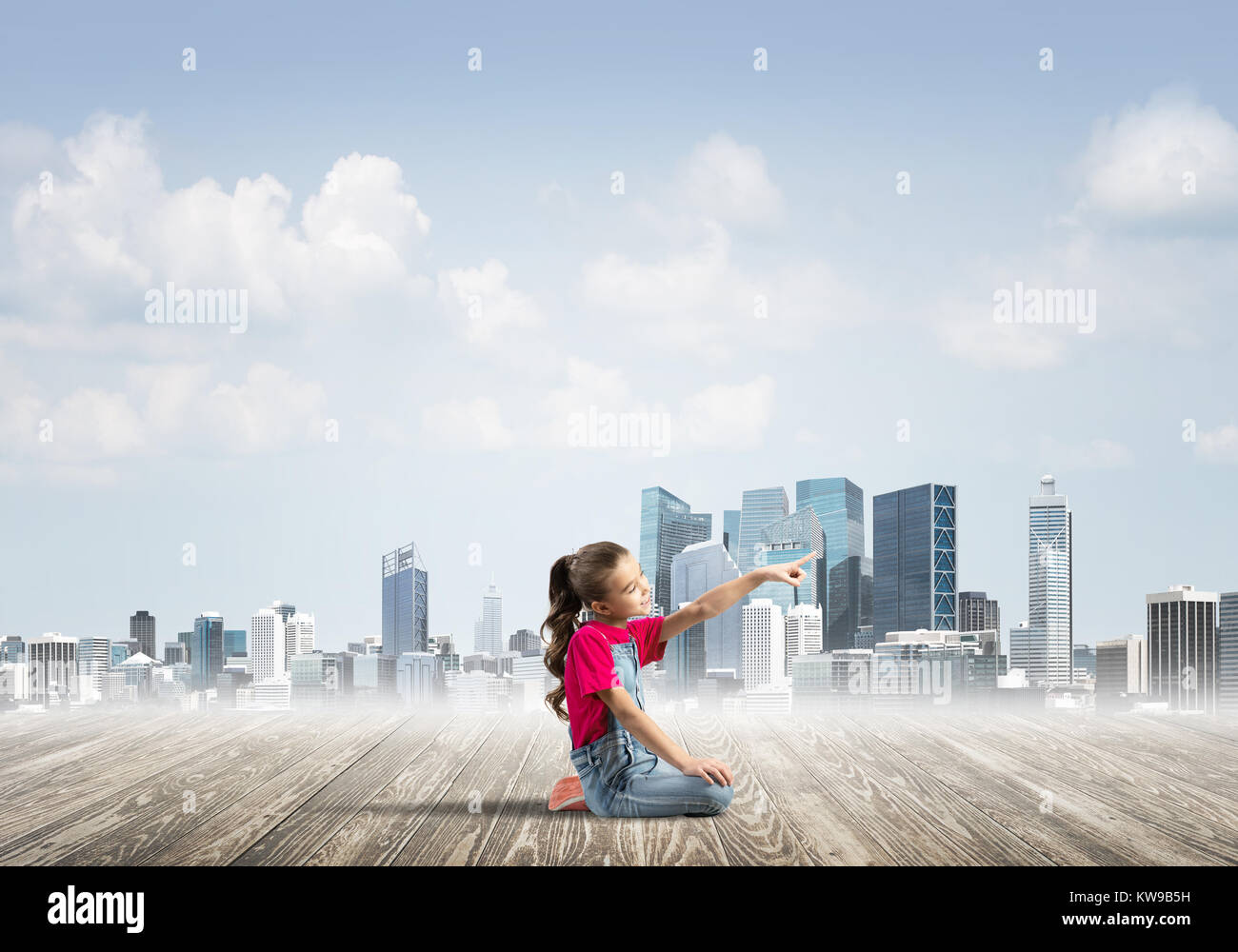 Cute kid girl sitting on wooden floor and pointing with finger Stock ...
