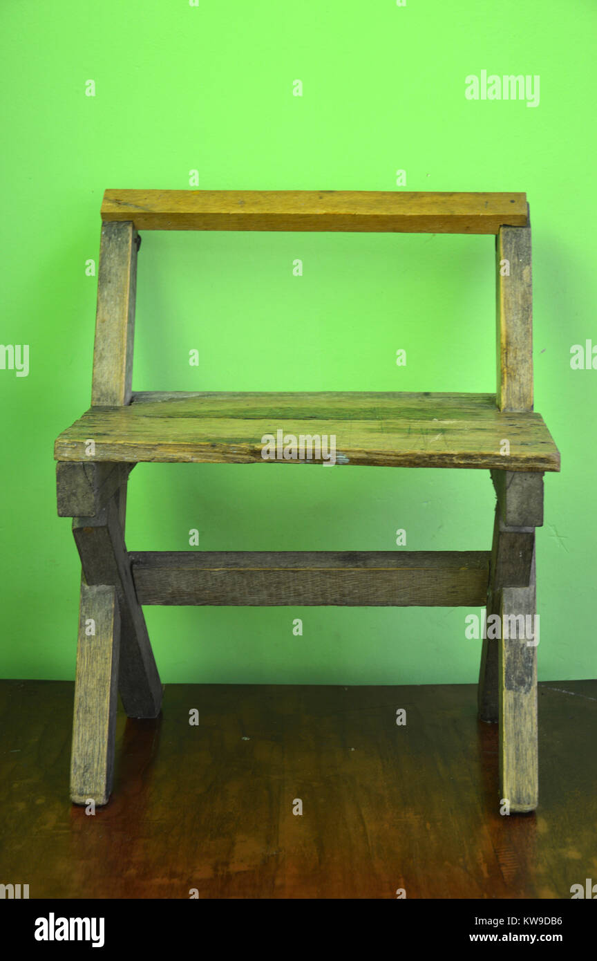 old used wooden chairs on the green wall Stock Photo Alamy