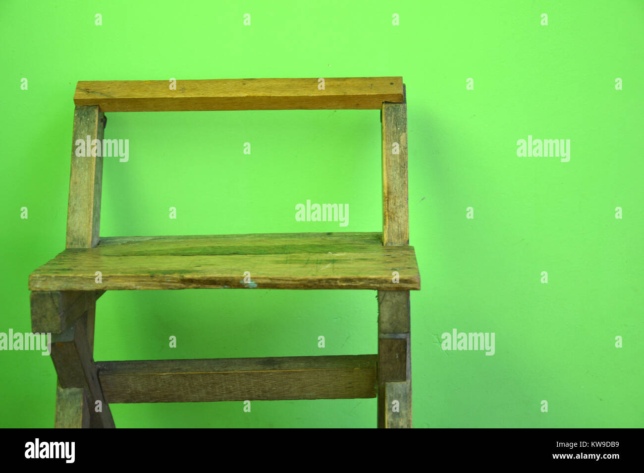 old used wooden chairs on the green wall Stock Photo Alamy