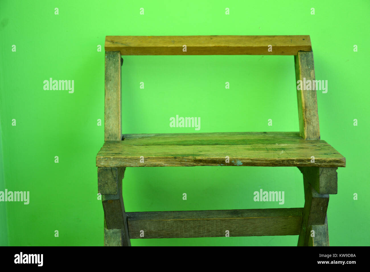 old used wooden chairs on the green wall Stock Photo Alamy