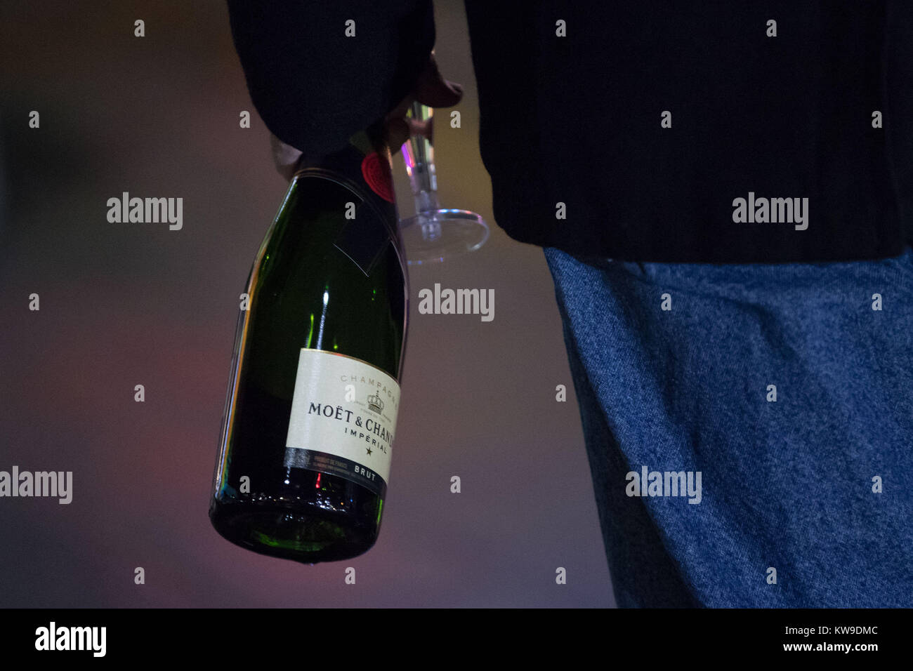 A reveller is seen drinking champagne during the New Year celebrations on Broad Street, Birmingham. Stock Photo