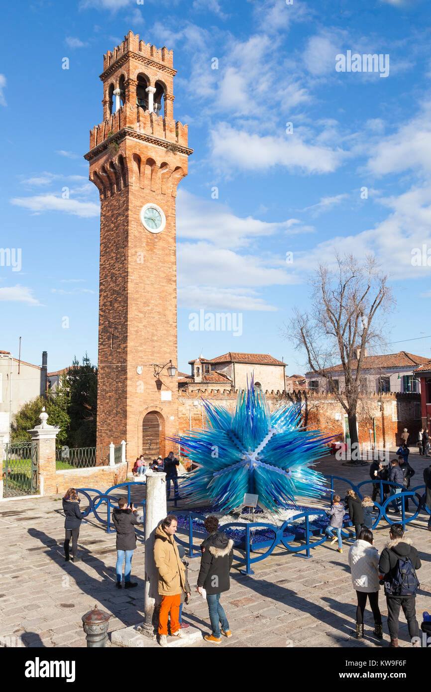 Campo San Stefano the historic Clock Tower and the Comet Glass Star, Murano, Venice, Italy with tourists in winter sunshine Stock Photo