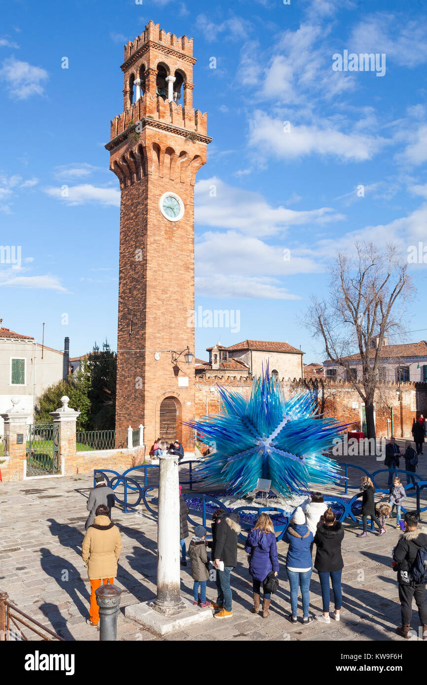 Murano, Venice, Italy, a group of tourists admiring the Clock Tower in Campo San Stefano and the Comet Glass Star by Simone Cenedese Stock Photo