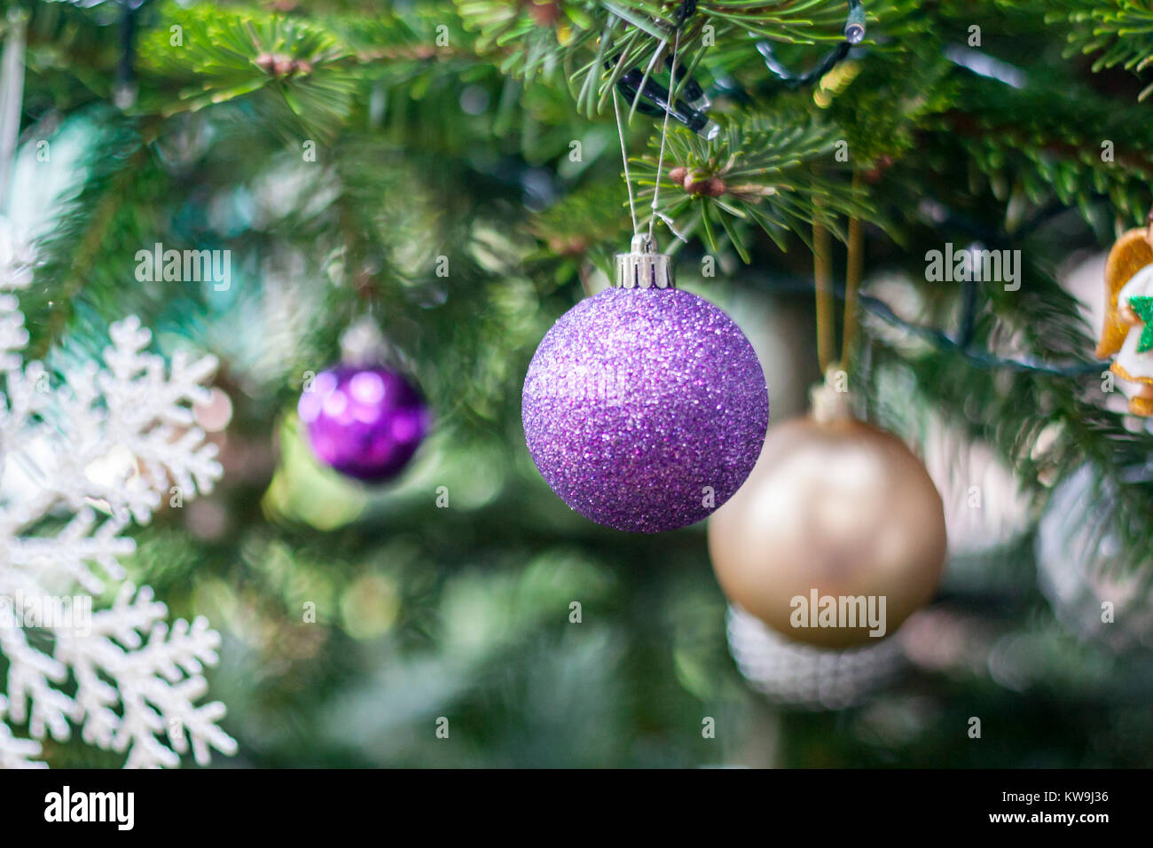 Closeup Christmas tree baubles, decorations blurred purple gold decorate lights snowflake, christmas concept, tradition traditions symbolise symbols Stock Photo