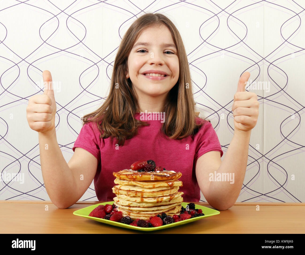happy little girl with pancakes and thumbs up Stock Photo Alamy