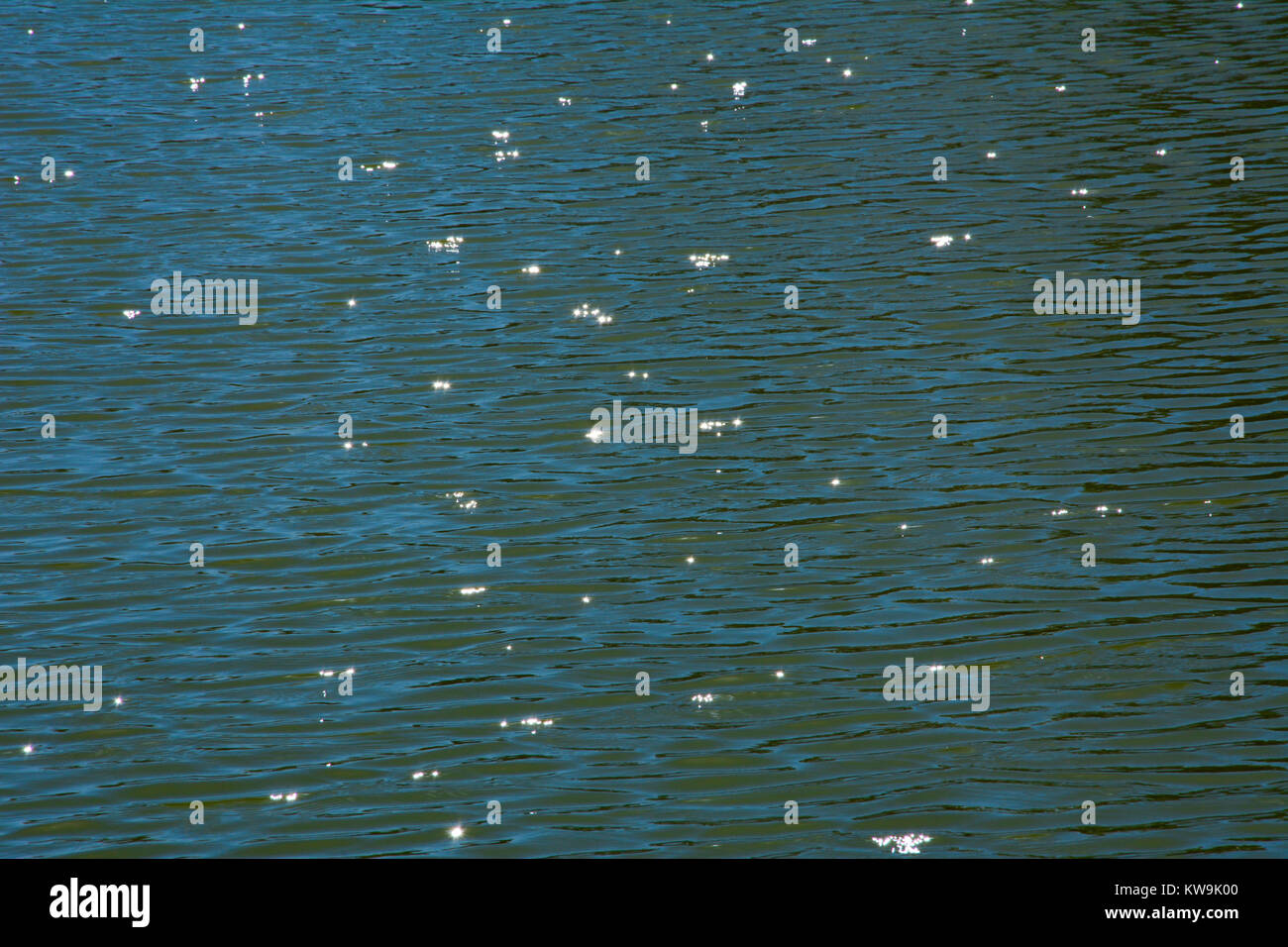 Sun rays reflecting star effect in water surface Stock Photo