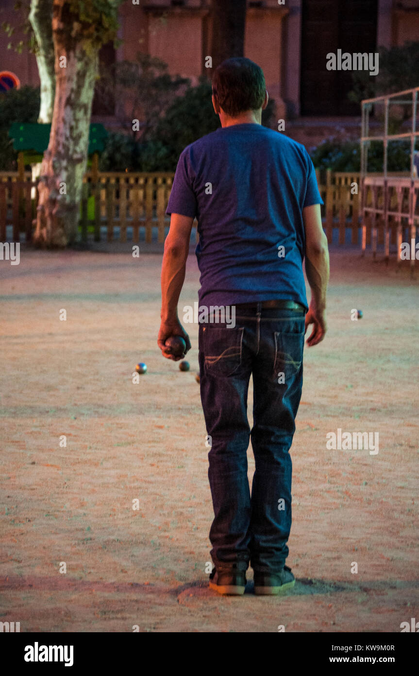 Corsica: a man playing petanque, the traditional Provencal game with boules originated in 1907 in France, in a square of Ile-Rousse (Red Island) Stock Photo