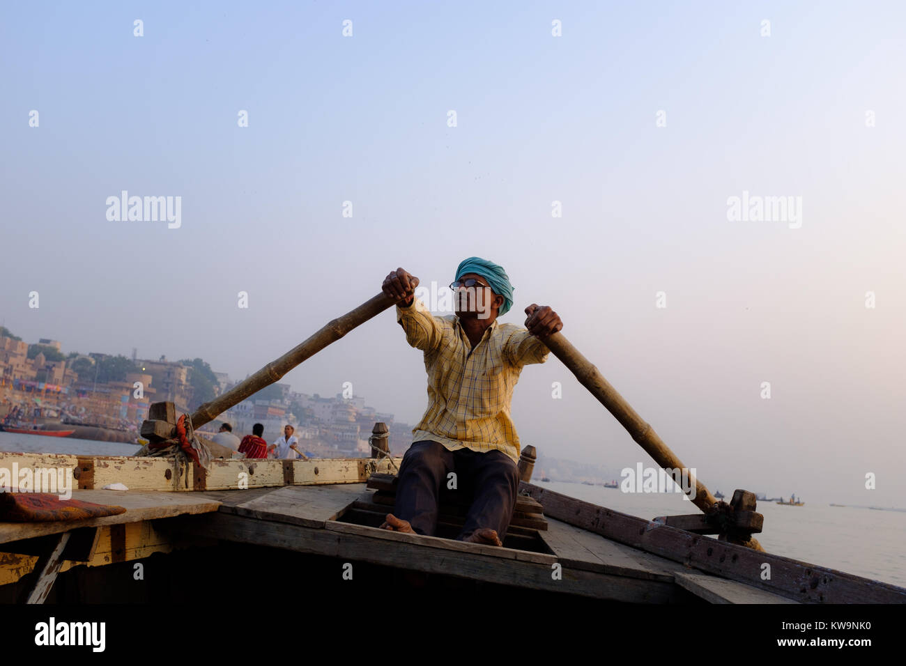 Man rowing boat on Ganges River in Varanasi, northern India. Stock Photo
