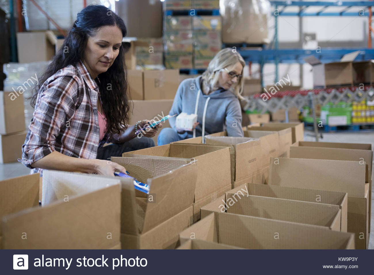 Female volunteers filling donation boxes in warehouse Stock Photo Alamy