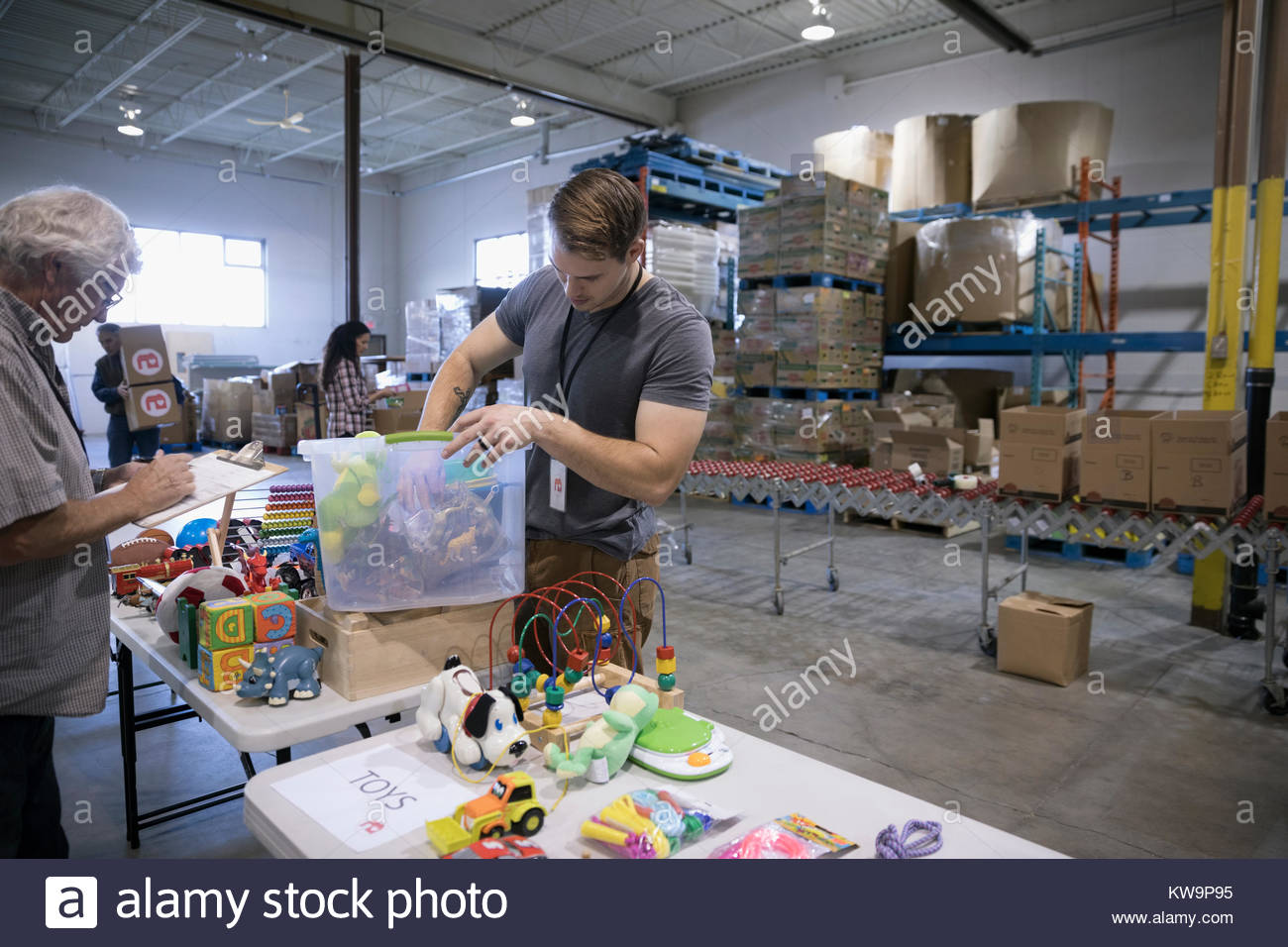 Male volunteers sorting toys for toy drive in warehouse Stock Photo Alamy