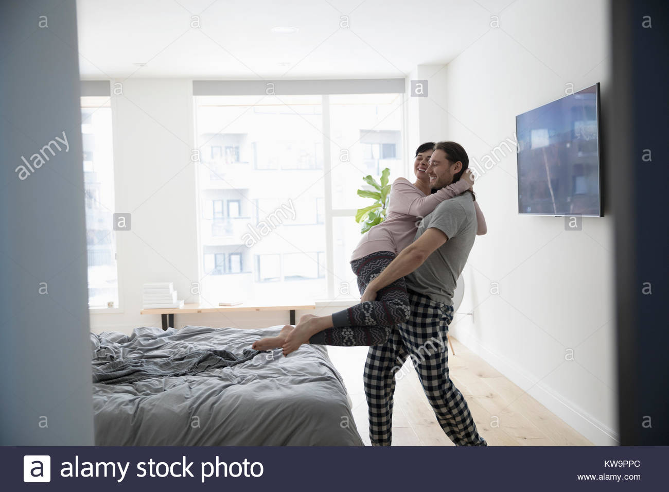 Playful,romantic husband carrying girlfriend to bed Stock Photo Alamy