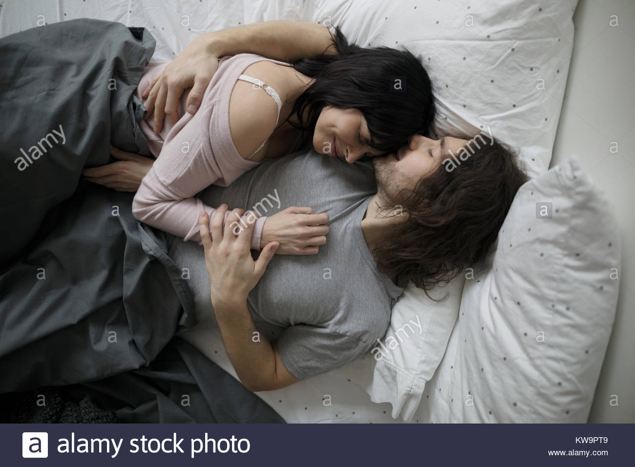 Affectionate,romantic couple cuddling in bed Stock Photo
