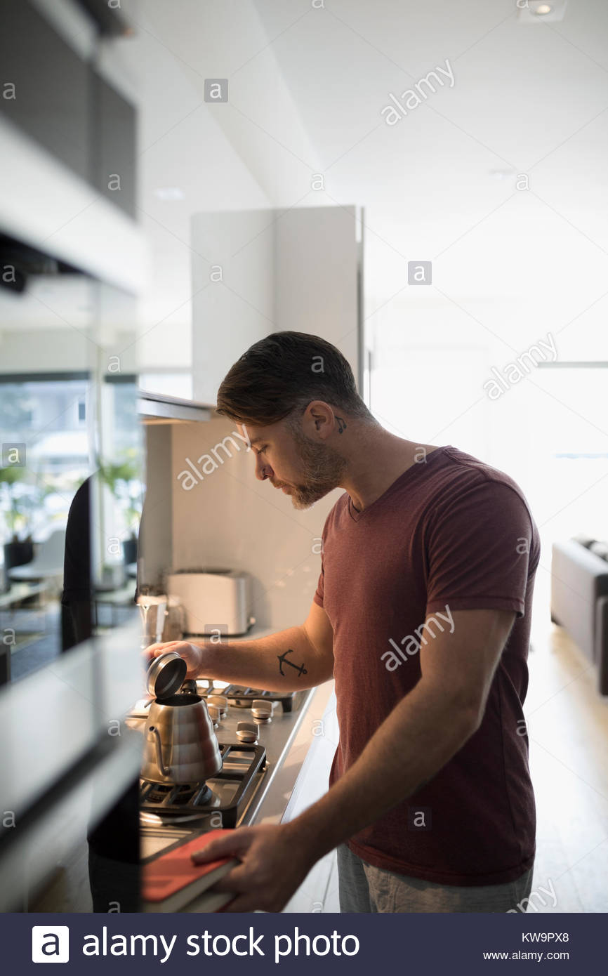 Man making coffee on the stove in kitchen Stock Photo Alamy