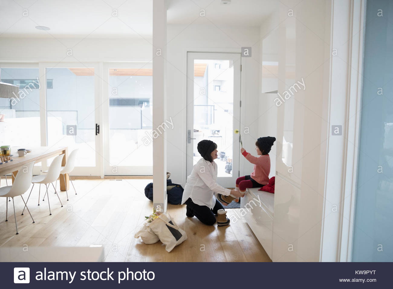 Mother putting boots on toddler daughter Stock Photo Alamy