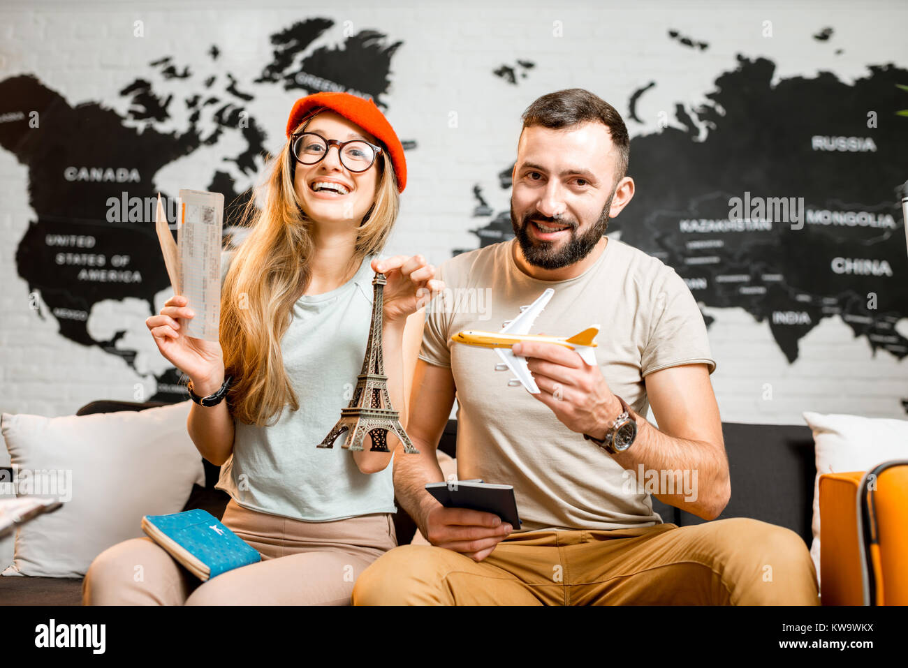 Young couple sitting with eiffel tower at the travel agency office on ...