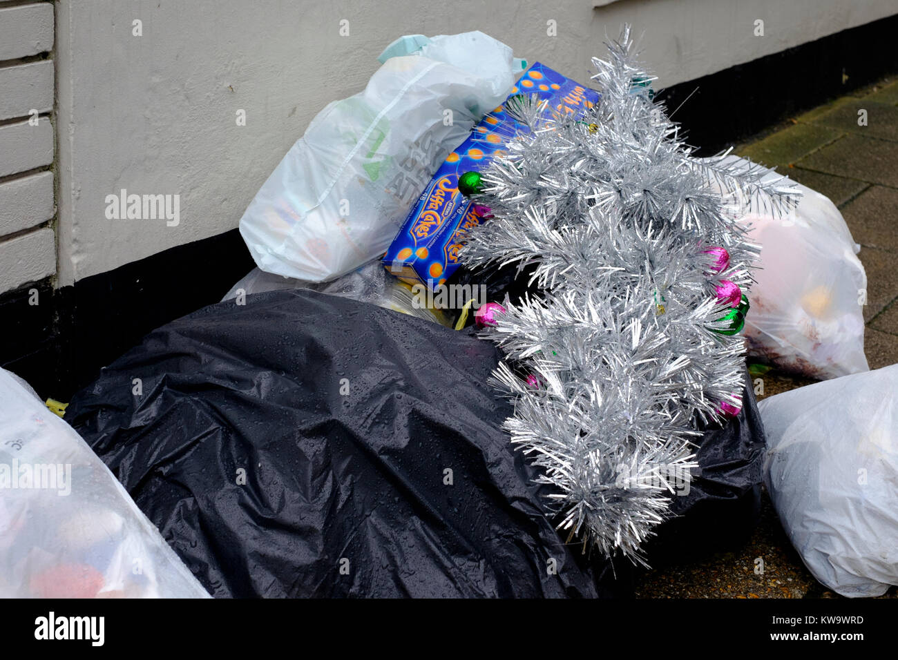 an artificial christmas tree is dumped along with bags of rubbish at