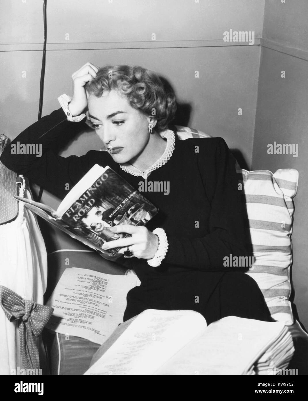 FLAMINGO ROAD, Joan Crawford reading novel, on set, 1949 Stock Photo