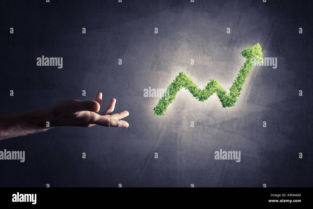Close of businessman hand and green growing graph as symbol of progress ...