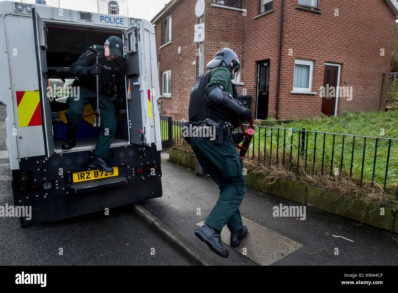 TSG (Tactical Support Group) officers leap out of a PSNI Land Rover to
