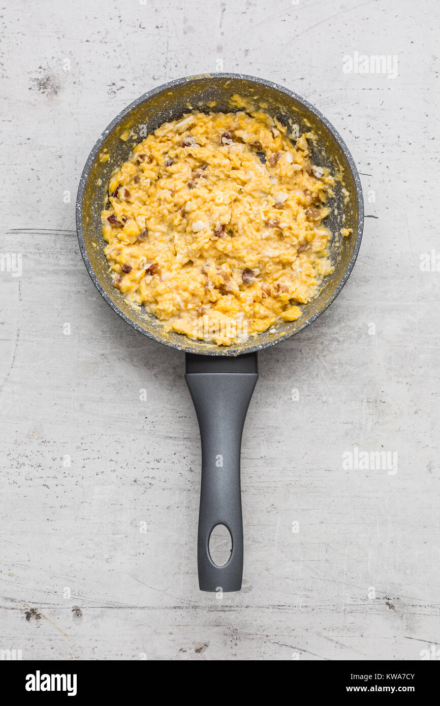 Ham and eggs. Scrambled eggs with bacon in ceramic pan Stock Photo Alamy