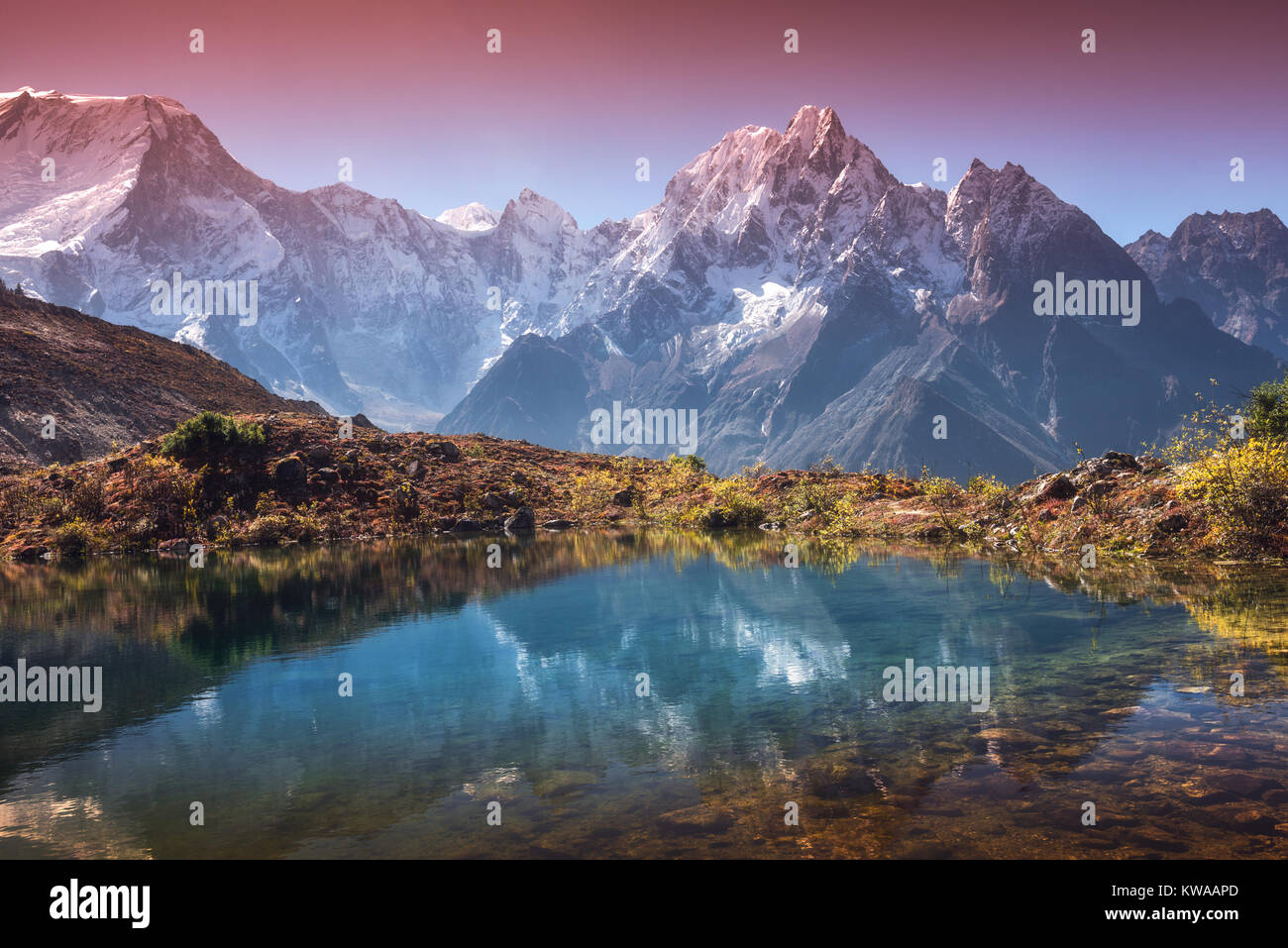 Beautiful landscape with high mountains with snow covered peaks, sky reflected in lake. Mountain valley with reflection in water in sunrise. Nepal. Am Stock Photo
