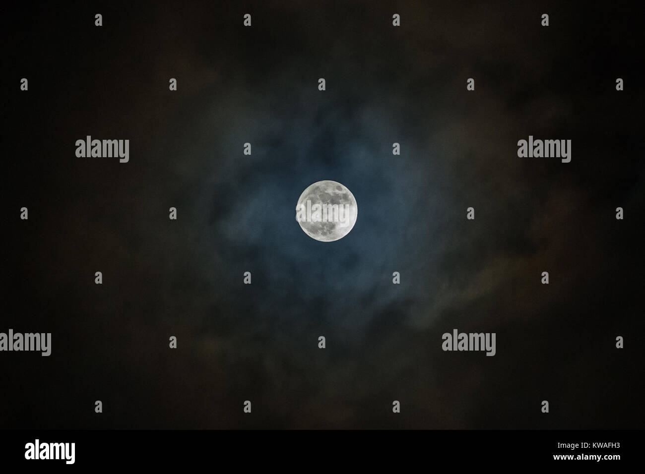 supermoon, also known as the wolf moon in the cloudy sky at night Stock ...