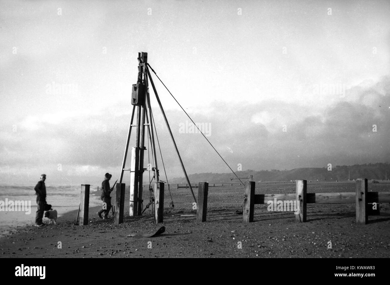 Workers driving in piles on a Westland beach, New Zealand. Date unknown. Stock Photo