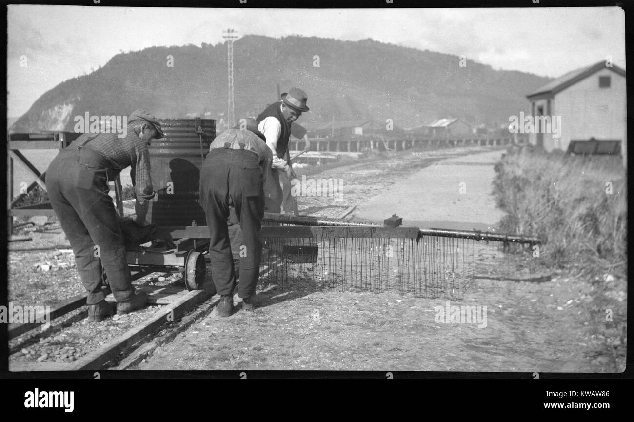 Men applying tar seal to a road in Greymouth, 1930s, Westland, New Zealand Stock Photo