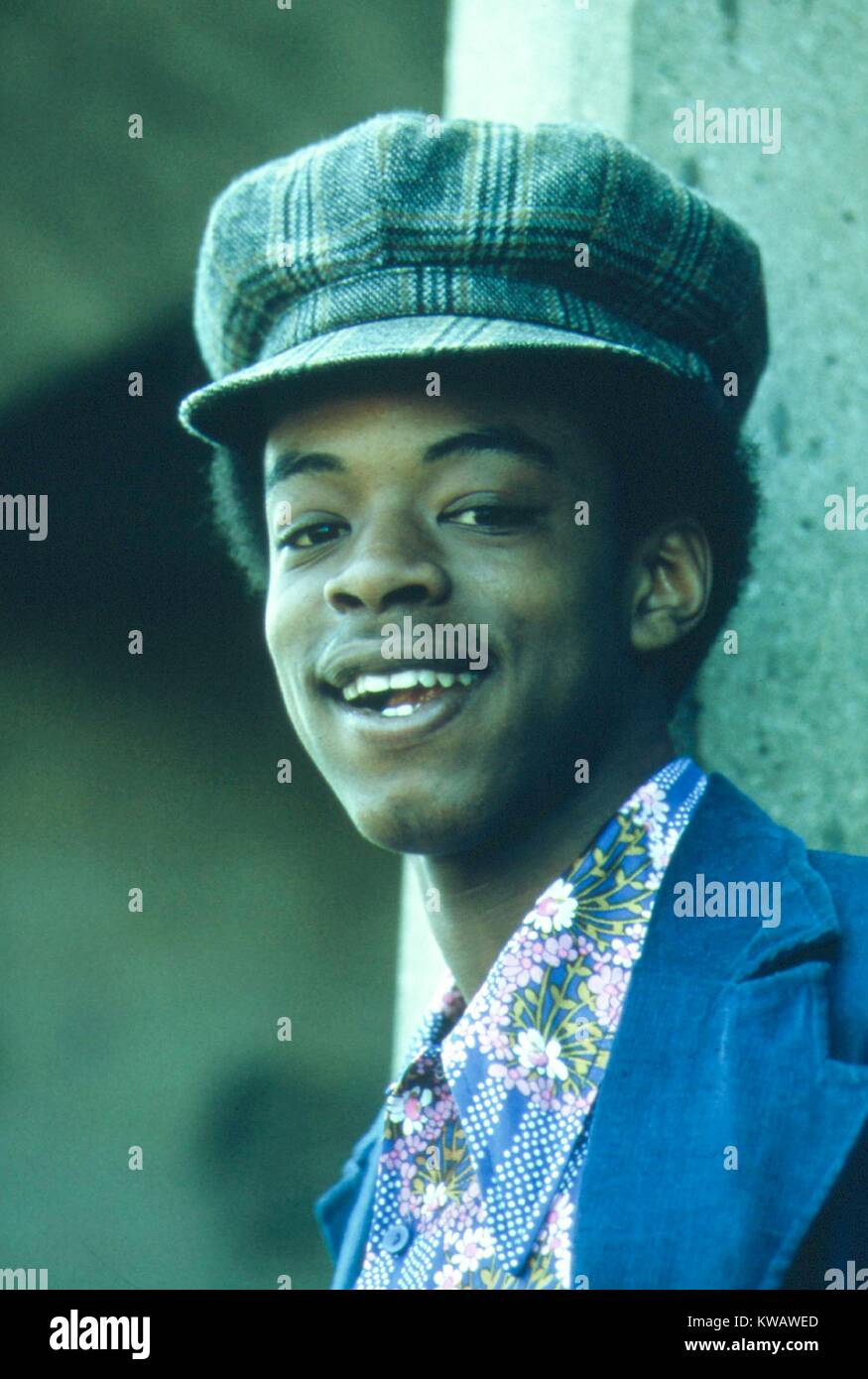 Dressed in plaid newsboy hat and floral shirt, a black teenage boy poses with a grin in the South Side of Chicago, Illinois, 1973. Image courtesy National Archives. Stock Photo